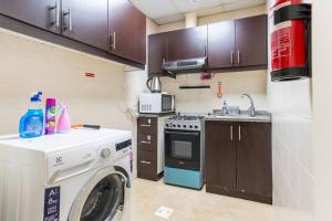 una cucina con lavatrice e lavatrice di Beautiful 1BR Apt with city views at silicon Dubai a Dubai