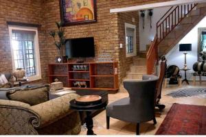 - un salon avec un canapé et une télévision dans l'établissement Stadigies Self-Catering Accommodation, à Marloth Park