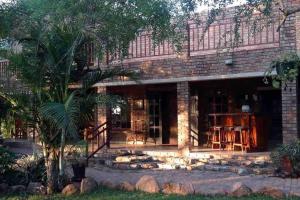 a brick house with a porch and a patio at Stadigies Self-Catering Accommodation in Marloth Park