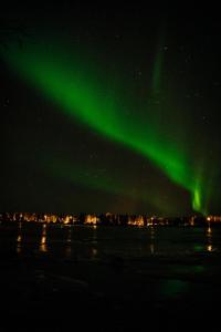 an aurora in the sky over a body of water at Stylish house in the heart of Lapland in Tornio in Tornio