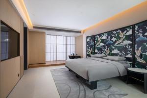 a bedroom with a large bed and a large window at GINCO Hotel Guangzhou Baiyun Airport in Guangzhou