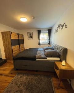 a bedroom with a large bed and a couch at Appartement Leo in Seefeld in Tirol