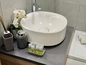 a bathroom with a white sink and some bottles on a counter at Diasof Apartments in Rome +101 photos