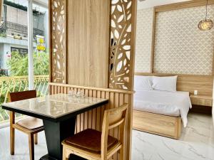 1 dormitorio con cama, mesa, mesa y sillas en Le's Apartment & Coffee, en Da Nang
