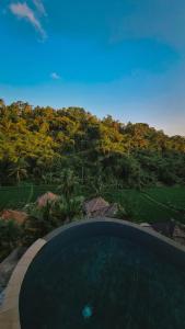 a swimming pool with a view of a forest at Tirta Sari in Tampaksiring