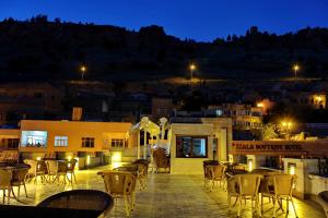 eine Terrasse mit Stühlen und Tischen in der Nacht in der Unterkunft HH Babil Konağı in Mardin