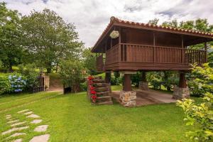 uma casa na árvore com um deque na relva em La Casina em Cudillero