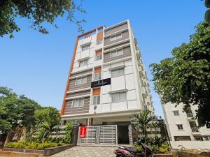 een hoog wit gebouw met een bord erop bij Srinika Inn in Hyderabad