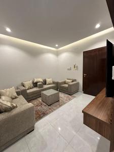 a living room with couches and a flat screen tv at شقق سحاب الفندقية in Qal'at Bishah