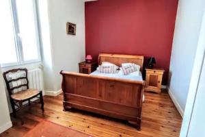 een slaapkamer met een houten bed en een stoel bij Ker Lucie- Les Gîtes de la Côte d'Amour ! in Batz-sur-Mer
