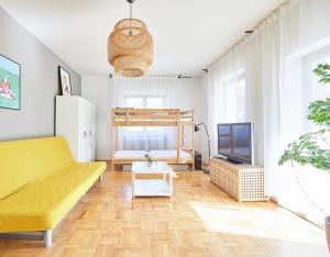 a living room with a yellow couch and a tv at APARTAMENTY JELEŚNIA in Jeleśnia