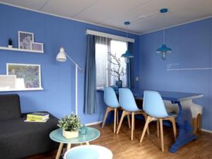 a living room with blue walls and a table and chairs at Van Gogh-style chalet near the Loonse and Drunense Duinen in Udenhout