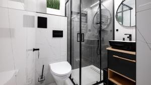 een badkamer met een douche, een toilet en een wastafel bij Barbara Ustroń, Sun & Snow in Ustroń