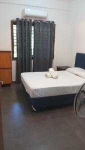 1 dormitorio con 1 cama con 2 toallas en Casa Naranja, en San Lorenzo