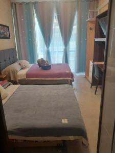 3 camas en una habitación con ventana en C'Est La Vie, en Xagħra