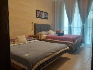 1 dormitorio con 2 camas y ventana en C'Est La Vie, en Xagħra