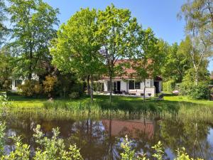 Sint NicolaasgaにあるSpacious home with a garden near the Langweerder Wielenの池のある家