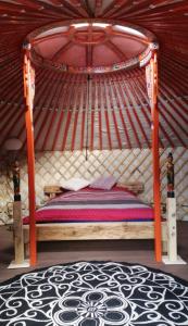 a bed in a yurt with a wooden frame at Panorama Jurte über dem Uri-See B in Sisikon