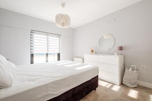 een witte slaapkamer met een groot bed en een spiegel bij Luminous Flat 7 min to Arcadium Mall in Ankara in Ankara