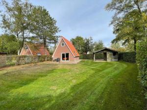 een huis in het midden van een grasveld bij Holiday home Landgoed Eysinga State 4 in Sint Nicolaasga