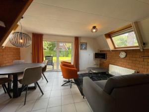 een woonkamer met een tafel en stoelen bij Holiday home Landgoed Eysinga State 4 in Sint Nicolaasga