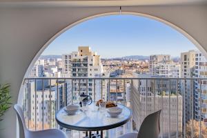 Zimmer mit einem Tisch und Stadtblick in der Unterkunft La Porte Bleue - Charmant appt in Marseille