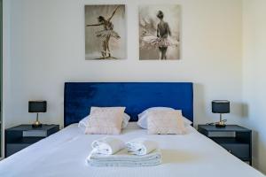 ein Schlafzimmer mit einem Bett mit zwei Nachttischen und zwei Bildern in der Unterkunft La Porte Bleue - Charmant appt in Marseille