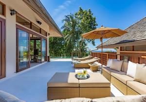 patio esterno con divani e ombrellone di Aspire Villas a Salad Beach
