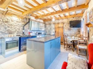 a kitchen with blue cabinets and a stone wall at Carnau Bach uk45822 in Llandegley