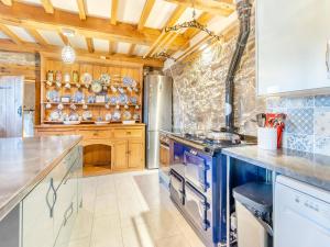 a large kitchen with wooden cabinets and blue appliances at Carnau Bach uk45822 in Llandegley