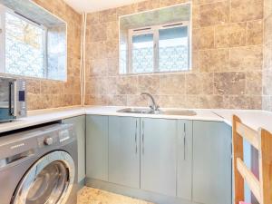 a laundry room with a washing machine and a sink at Carnau Bach uk45822 in Llandegley