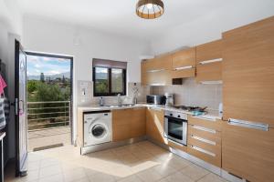 a kitchen with a washer and a washing machine at Almyrida Bay View House II BY APOKORONAS-VILLAS in Almyrida