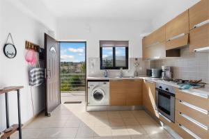 a kitchen with a washer and a washing machine at Almyrida Bay View House II BY APOKORONAS-VILLAS in Almyrida