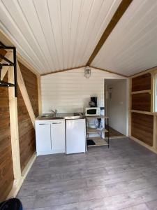 una cocina con electrodomésticos blancos en una habitación de madera en Camping Via Romana, en Prunelli-di-Fiumorbo