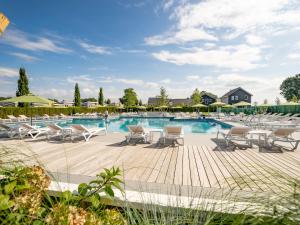 a pool with chaise lounge chairs and a lot ofvationvationvationvationangering at Holiday home Resort Mooi Bemelen I in Bemelen