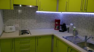 eine Küche mit hellgrünen Schränken und einer Spüle in der Unterkunft DUO Apartmanok in Sárvár