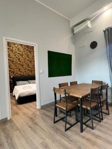 una sala da pranzo con tavolo, sedie e letto di Regis 2 Appartamenti Resort centro storico a Chivasso