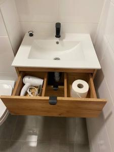 a bathroom with a sink and a roll of toilet paper at MH Apartments in Rzeszów