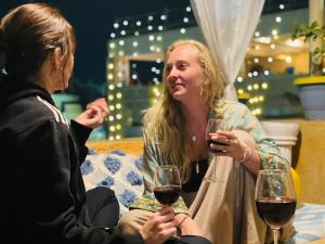 two women sitting on a couch with glasses of wine at Jaisalmer Hostel Crowd in Jaisalmer