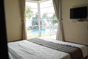 a bedroom with a bed and a large window at B&H Villa - Villa has swimming pool in Lang Co
