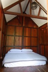 a bedroom with a bed in a wooden room at Jungle Zen Janda Baik Campsite in Kampung Janda Baik