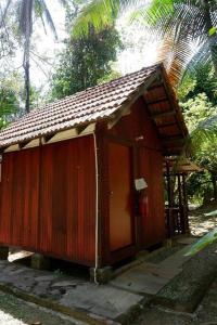 a small wooden building with a brown roof at Jungle Zen Janda Baik Campsite in Kampung Janda Baik