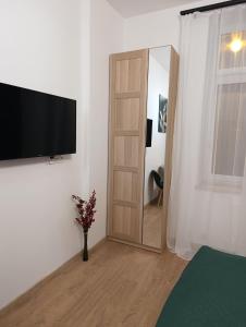 a room with a television on a wall next to a door at MH Apartments in Rzeszów