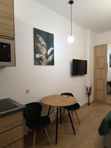 a living room with a table and chairs and a tv at MH Apartments in Rzeszów