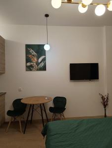a room with a table and a tv on a wall at MH Apartments in Rzeszów