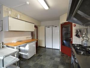 uma cozinha com armários brancos e um forno com placa de fogão em Welcoming Mansion near Forest in Bergeijk em Bergeijk