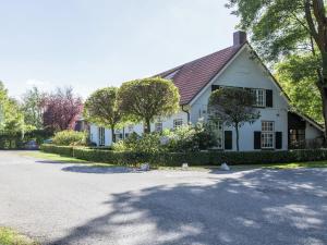 a white house with trees in front of a driveway at Welcoming Mansion near Forest in Bergeijk in Bergeijk