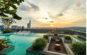 a swimming pool on the roof of a building with a sunset at ViiA Residences Kuala Lumpur, Five Senses in Kuala Lumpur