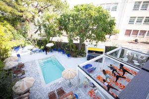 - une vue sur la piscine et le bâtiment dans l'établissement Hôtel Le Sud, à Juan-les-Pins