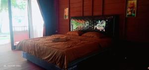 1 dormitorio con 1 cama con edredón marrón en Raflow Resort Raja Ampat en Tapokreng